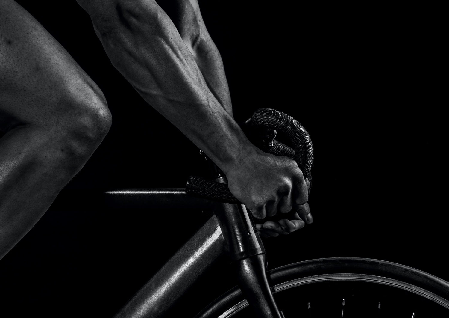 Close up of man riding a bicycle in black and white showcasing home gym equipment from The Fitness Connection
