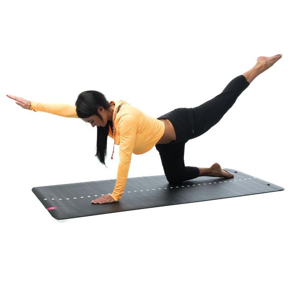 Woman using Escape Fitness yoga mat in black